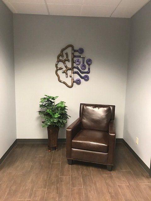 A chair in a room with a purple brain on the wall