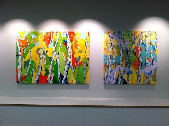 Two colorful paintings are hanging on a wall