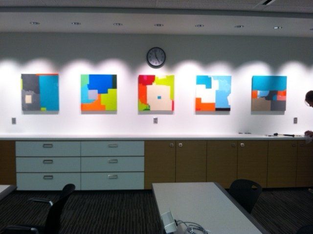 A room with a clock on the wall and paintings on the wall