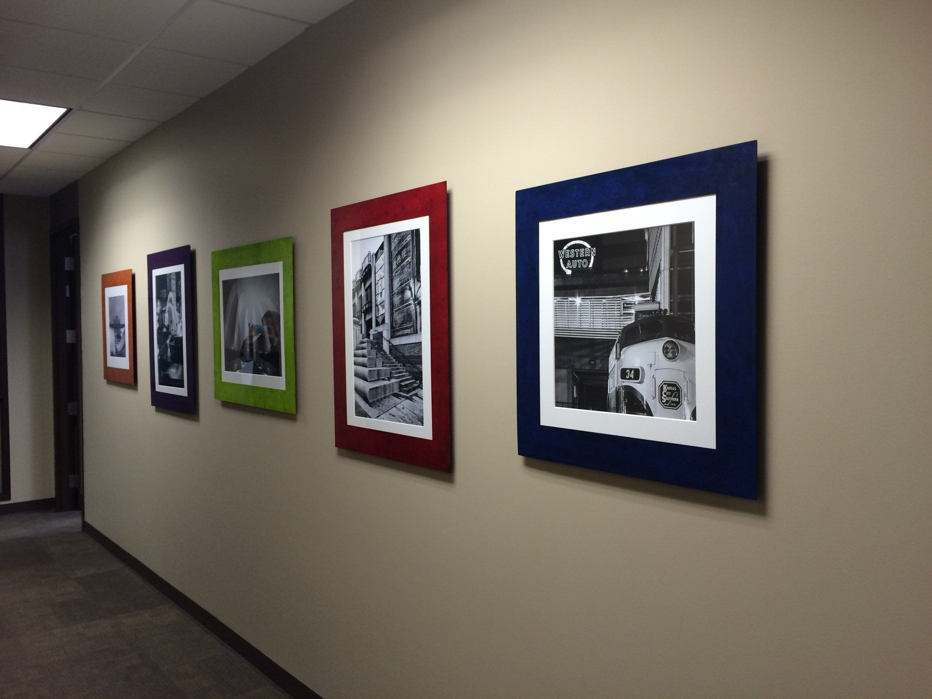 A hallway with a row of framed pictures on the wall
