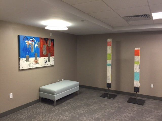 A room with a bench and a painting on the wall