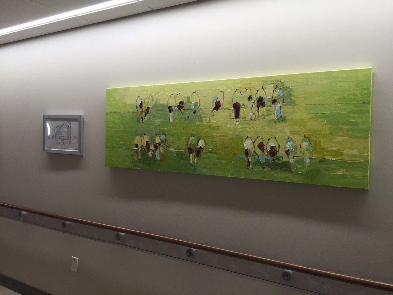 A painting of cows is hanging on a wall in a hallway.