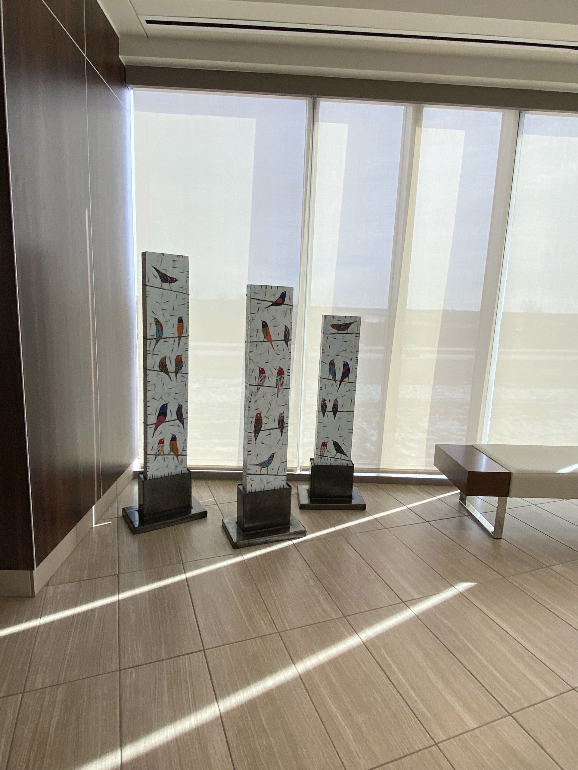 A room with three sculptures in front of a window