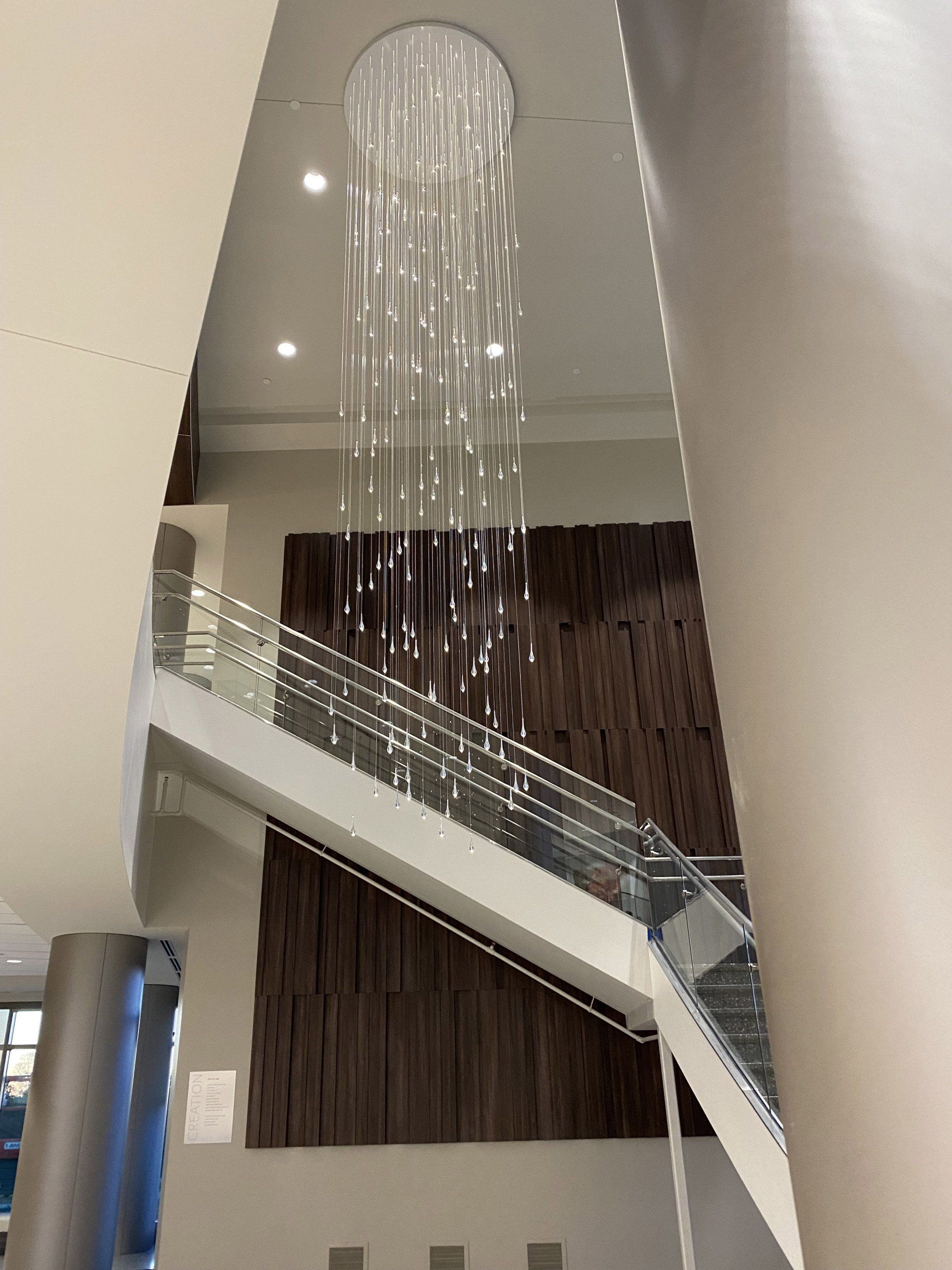 A staircase with a large chandelier hanging from the ceiling