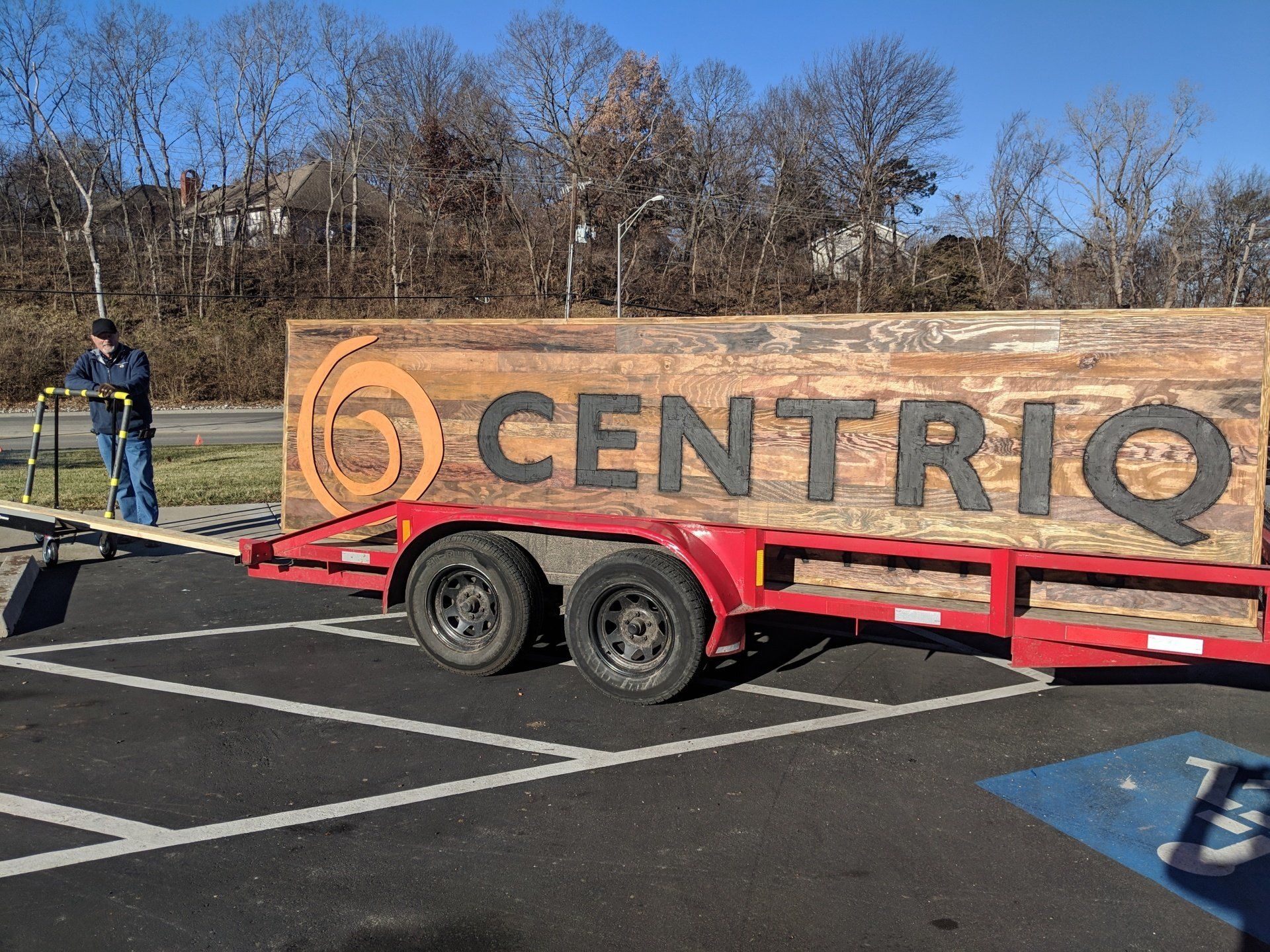 A large wooden sign on a trailer that says centriq