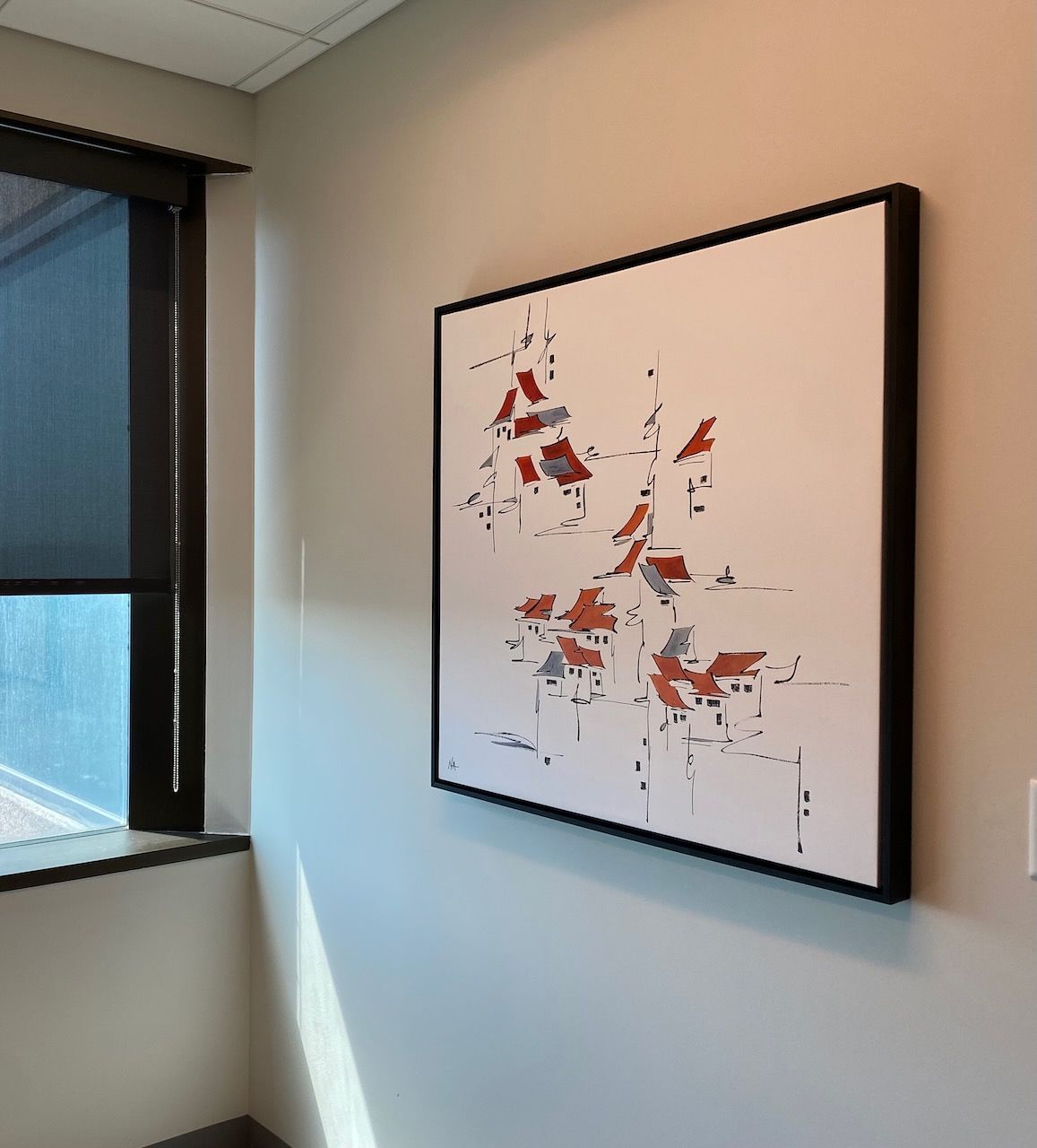 A painting is hanging on a wall next to a window