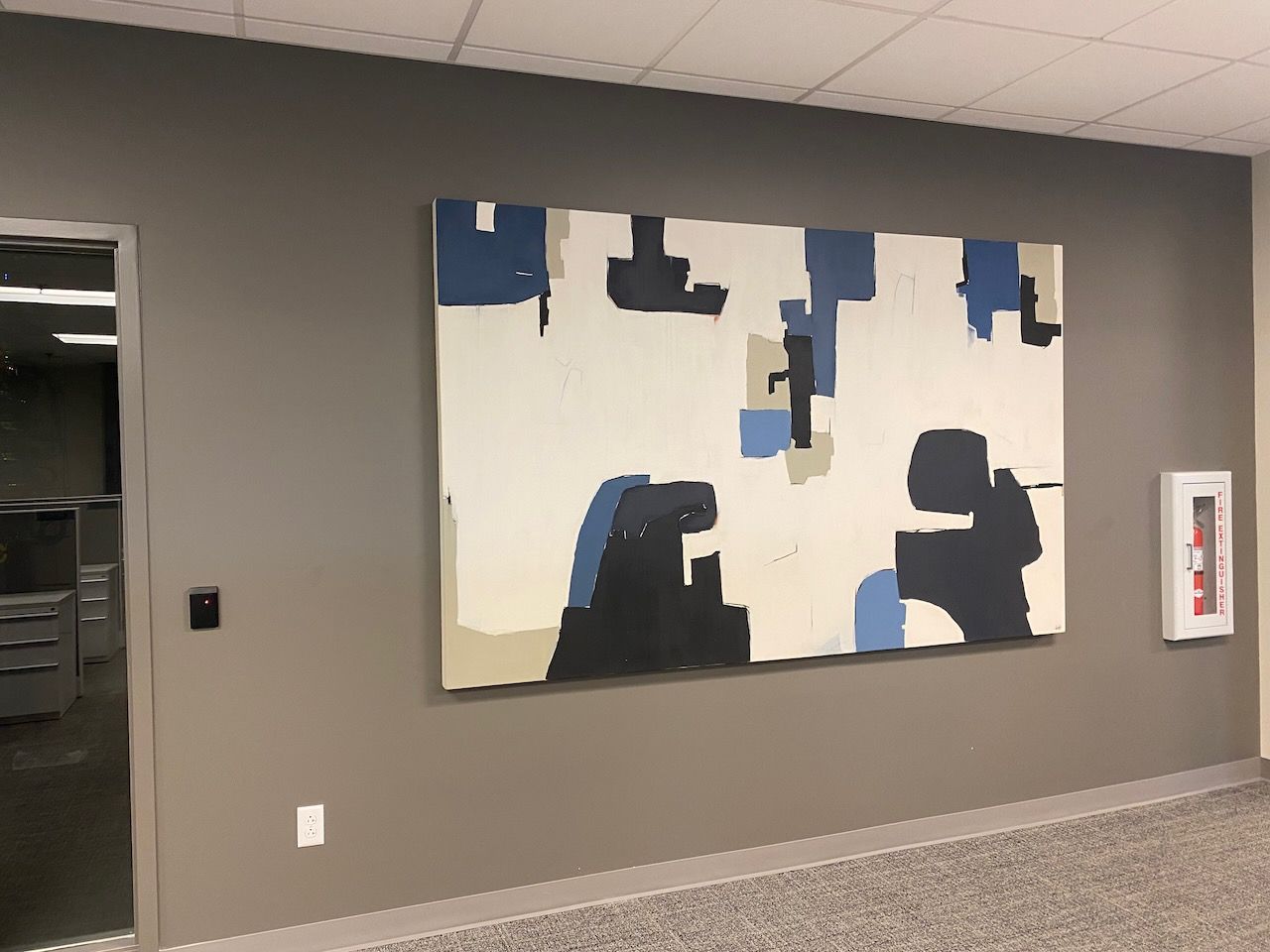 A large painting is hanging on a wall in a hallway
