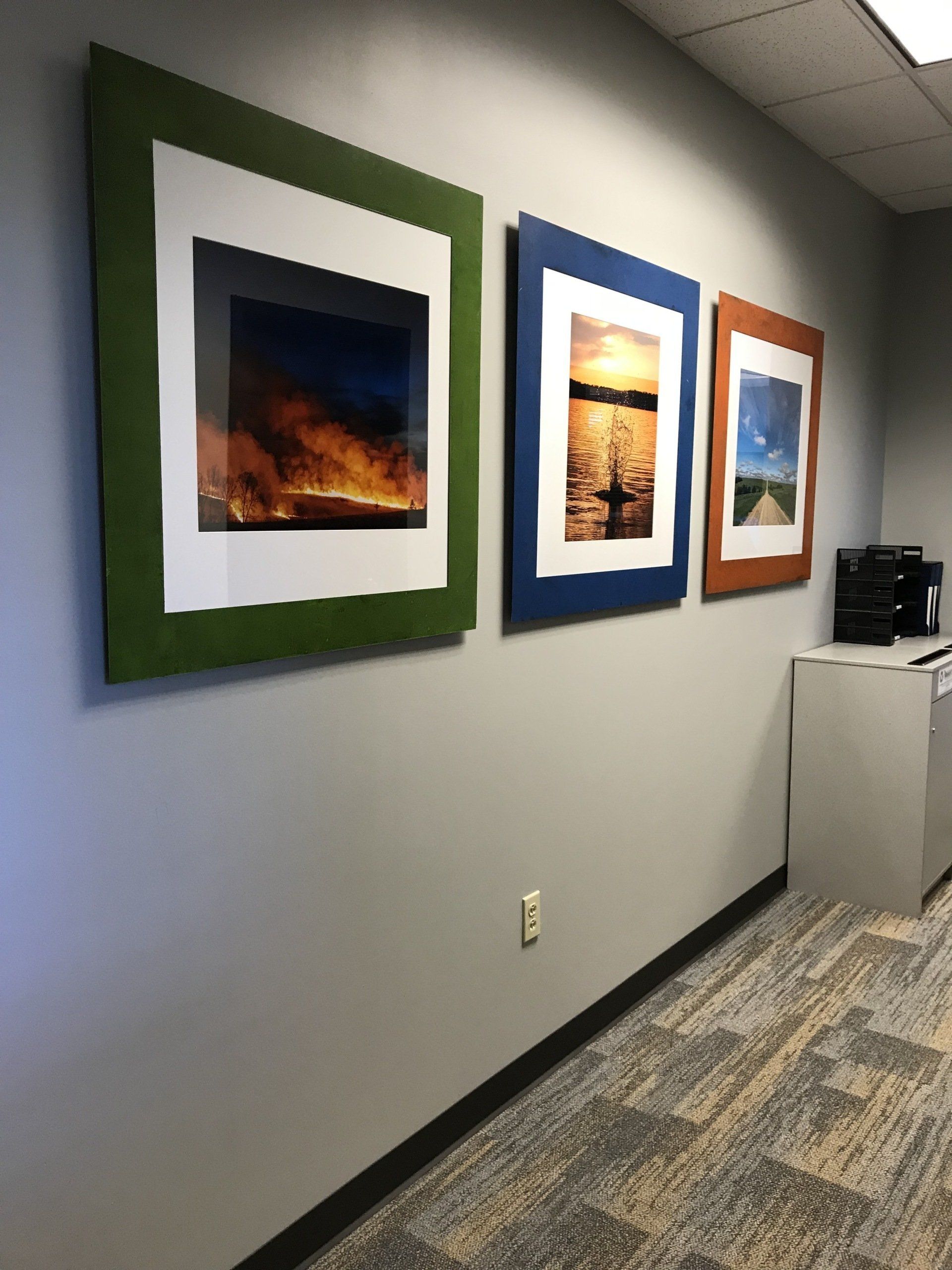 A hallway with a row of framed pictures on the wall.