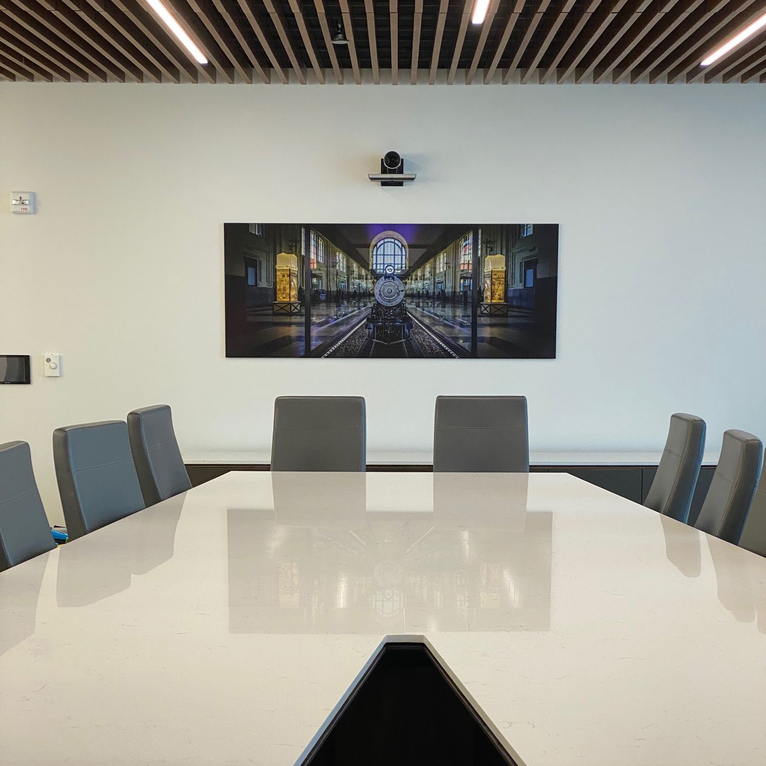 A conference room with a large picture on the wall above the table