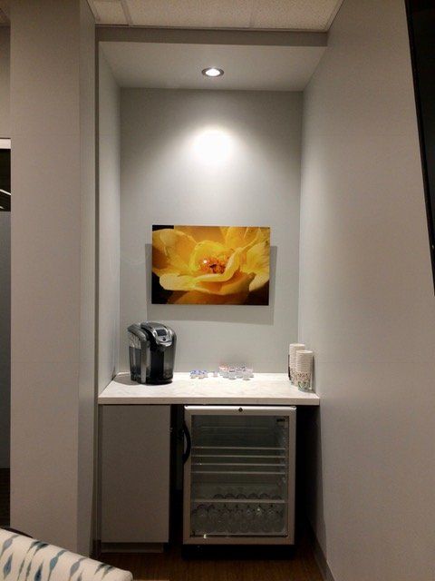 A room with a picture of a yellow flower on the wall