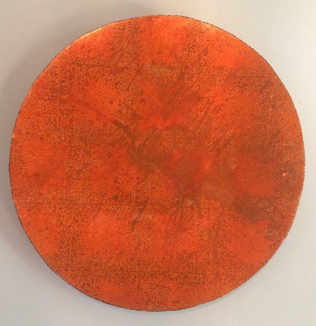 An orange circle is sitting on a white surface