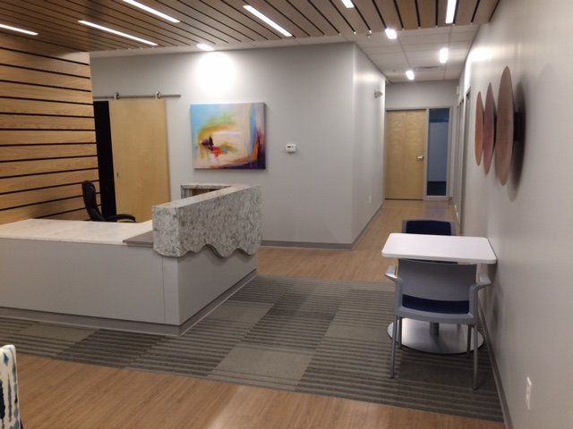 A hallway with a table and chairs and a painting on the wall