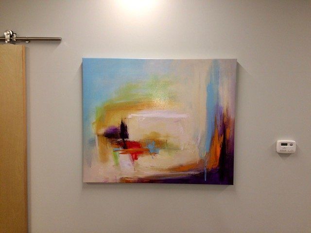 A large painting is hanging on a wall next to a door.