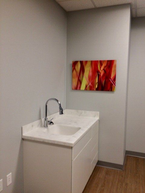 A bathroom with a sink and a painting on the wall.