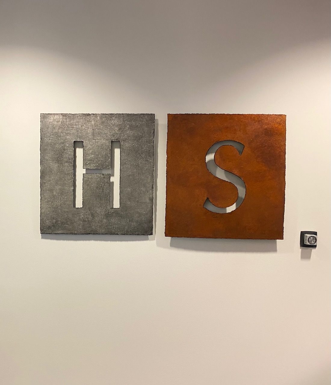 Two squares with the letters h and s cut out of them
