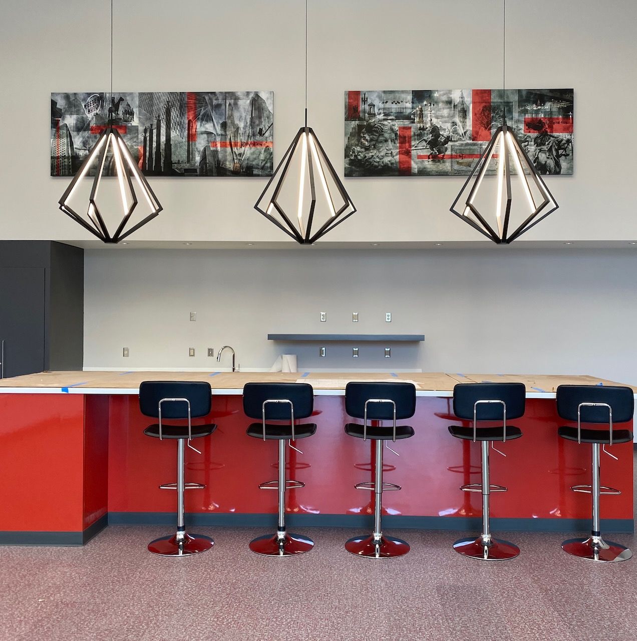 A row of bar stools in front of a red counter
