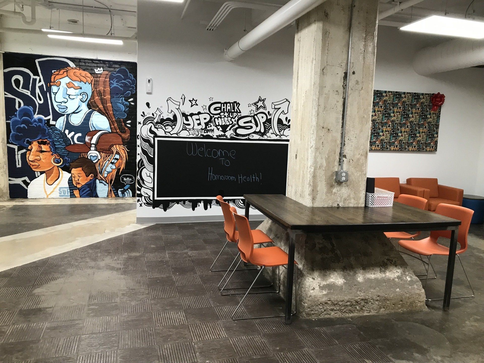 A room with a table and chairs and a mural on the wall