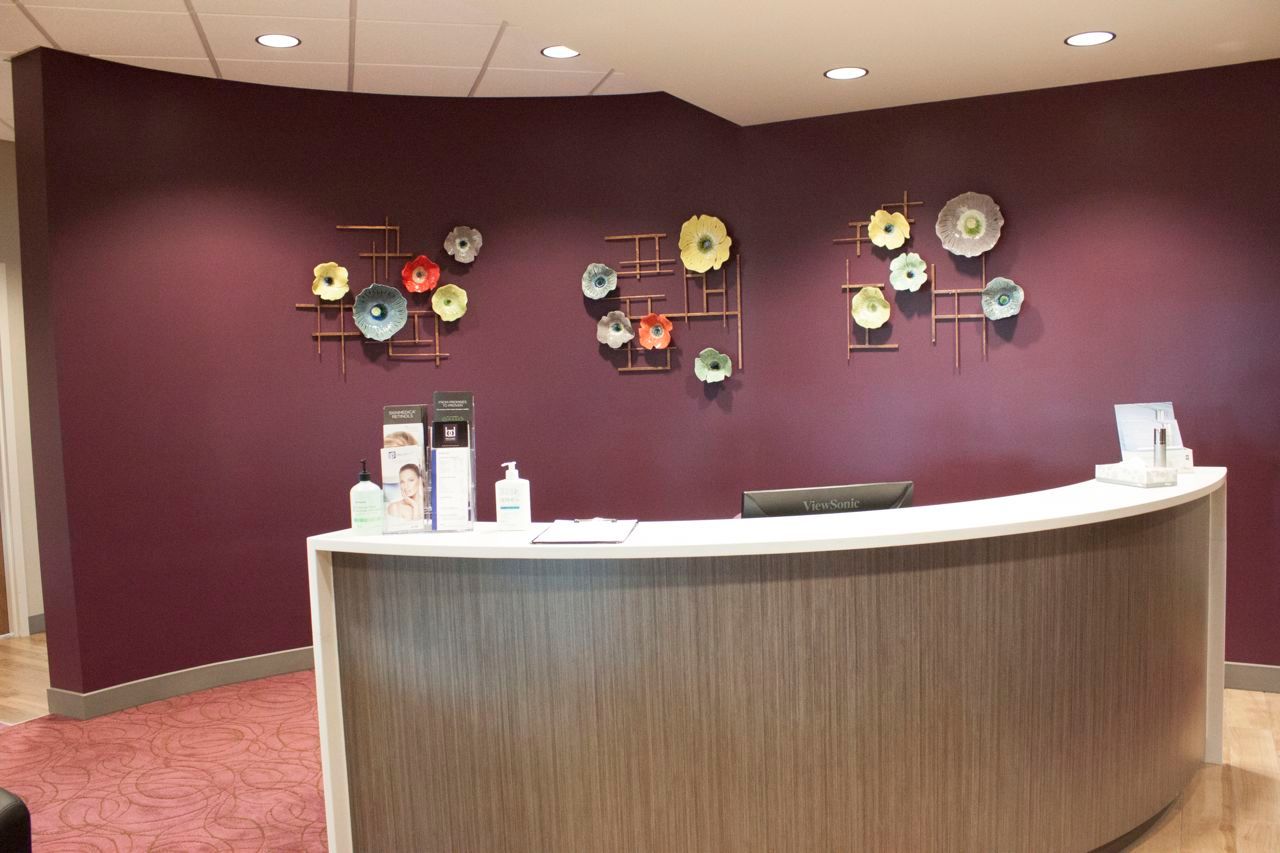 A reception area with purple walls and a curved counter