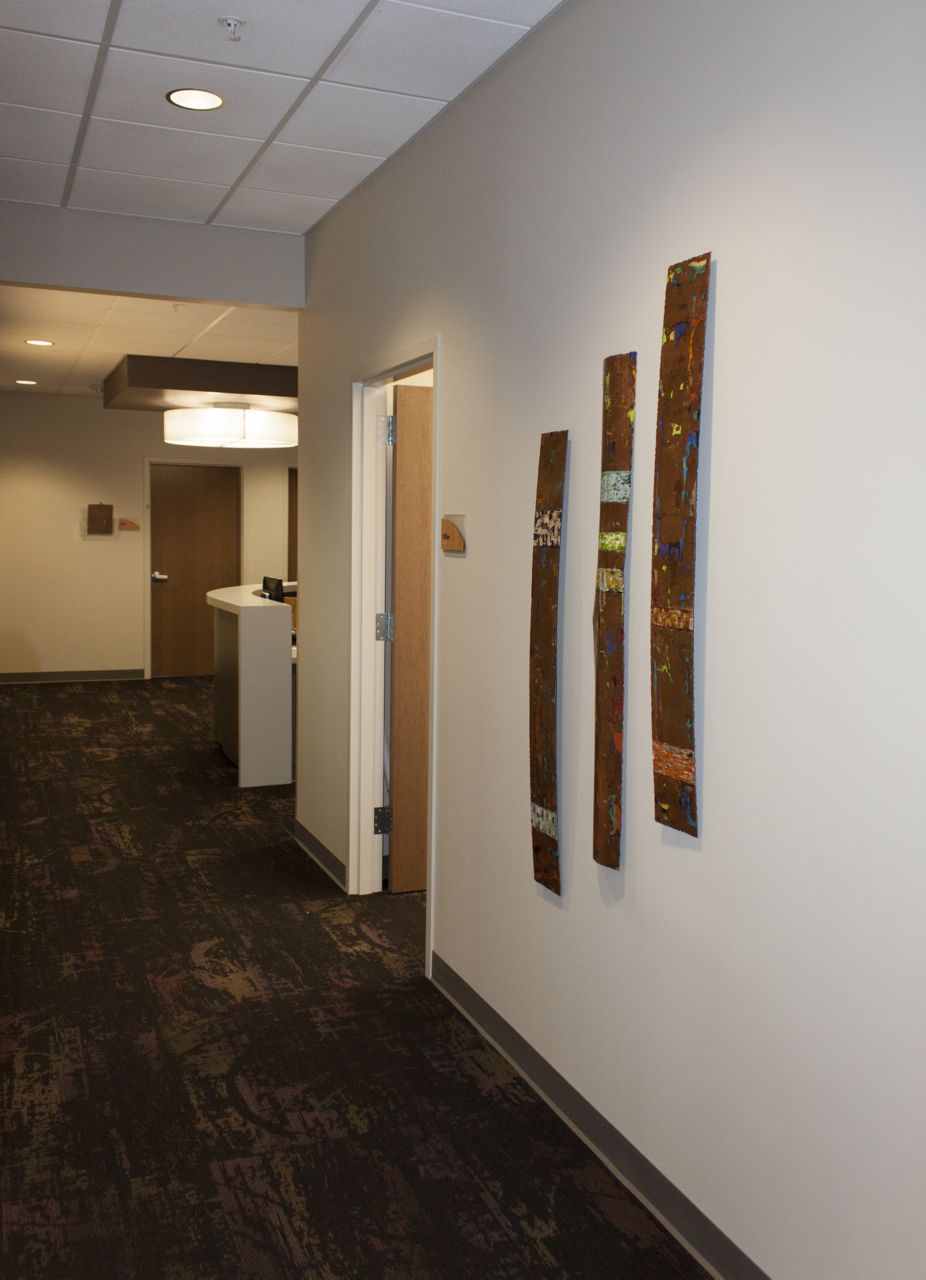 A hallway with three pieces of art on the wall