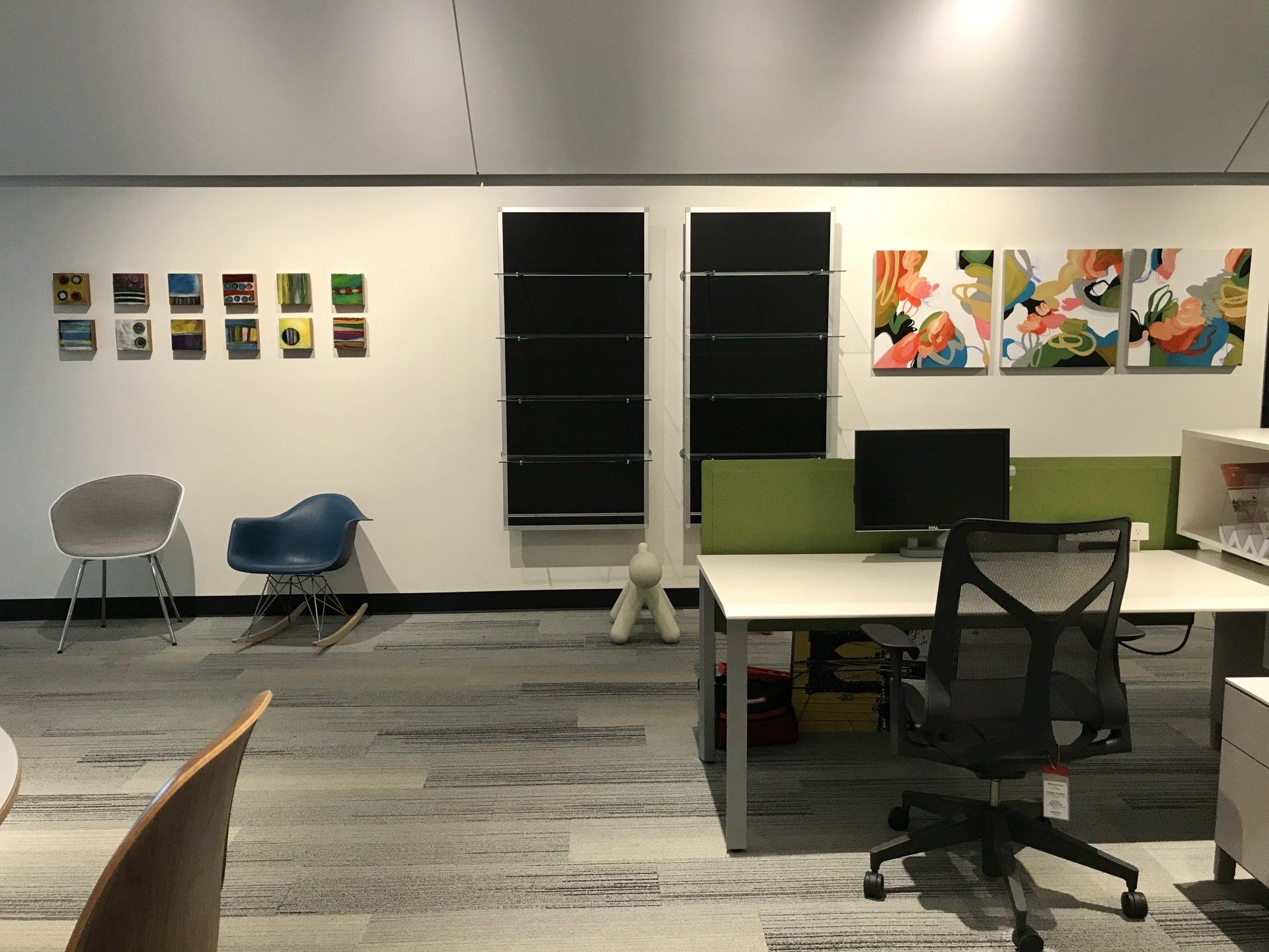 A room with a desk and chairs and paintings on the wall