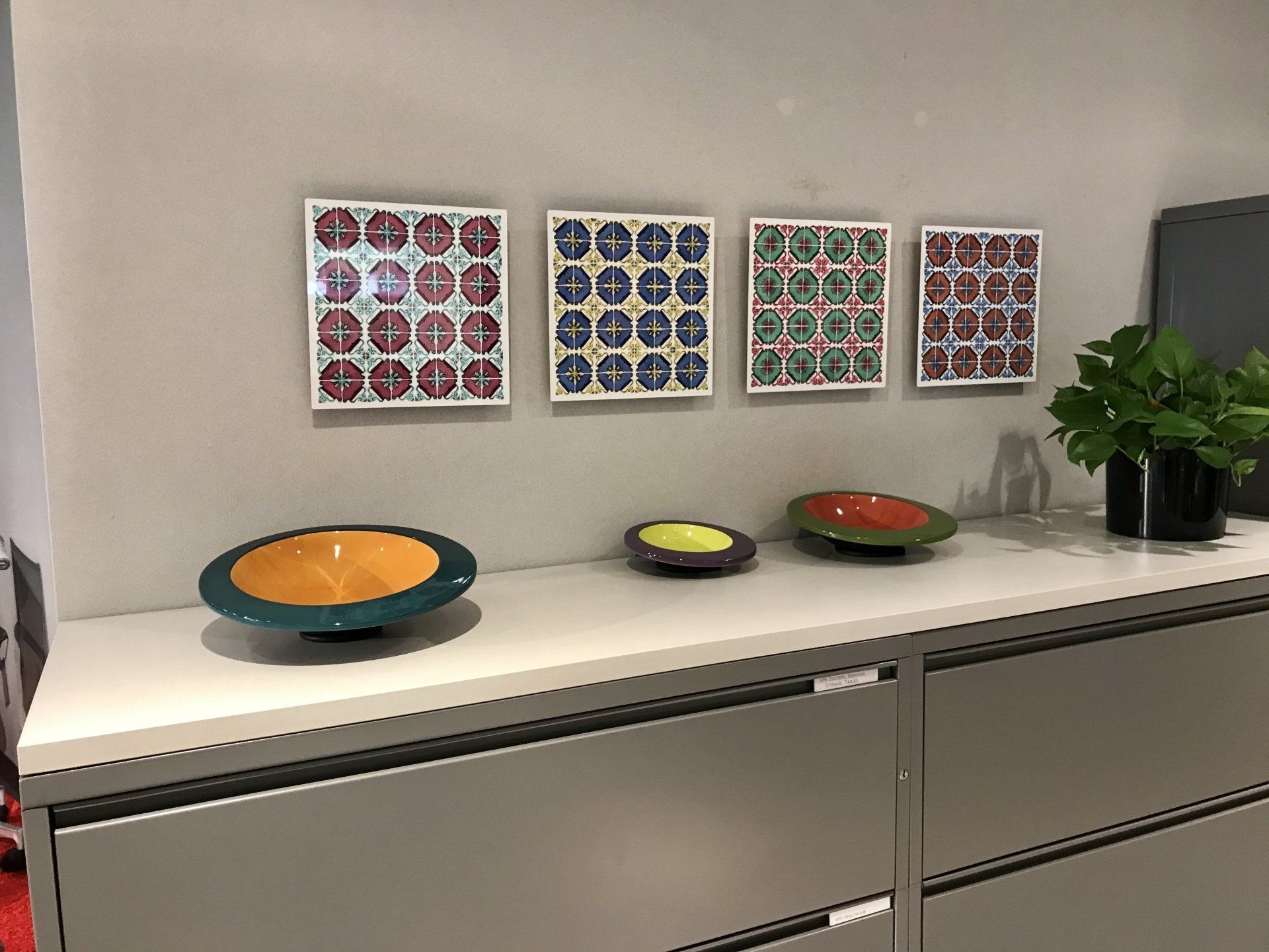 A shelf with three bowls and a plant on it.