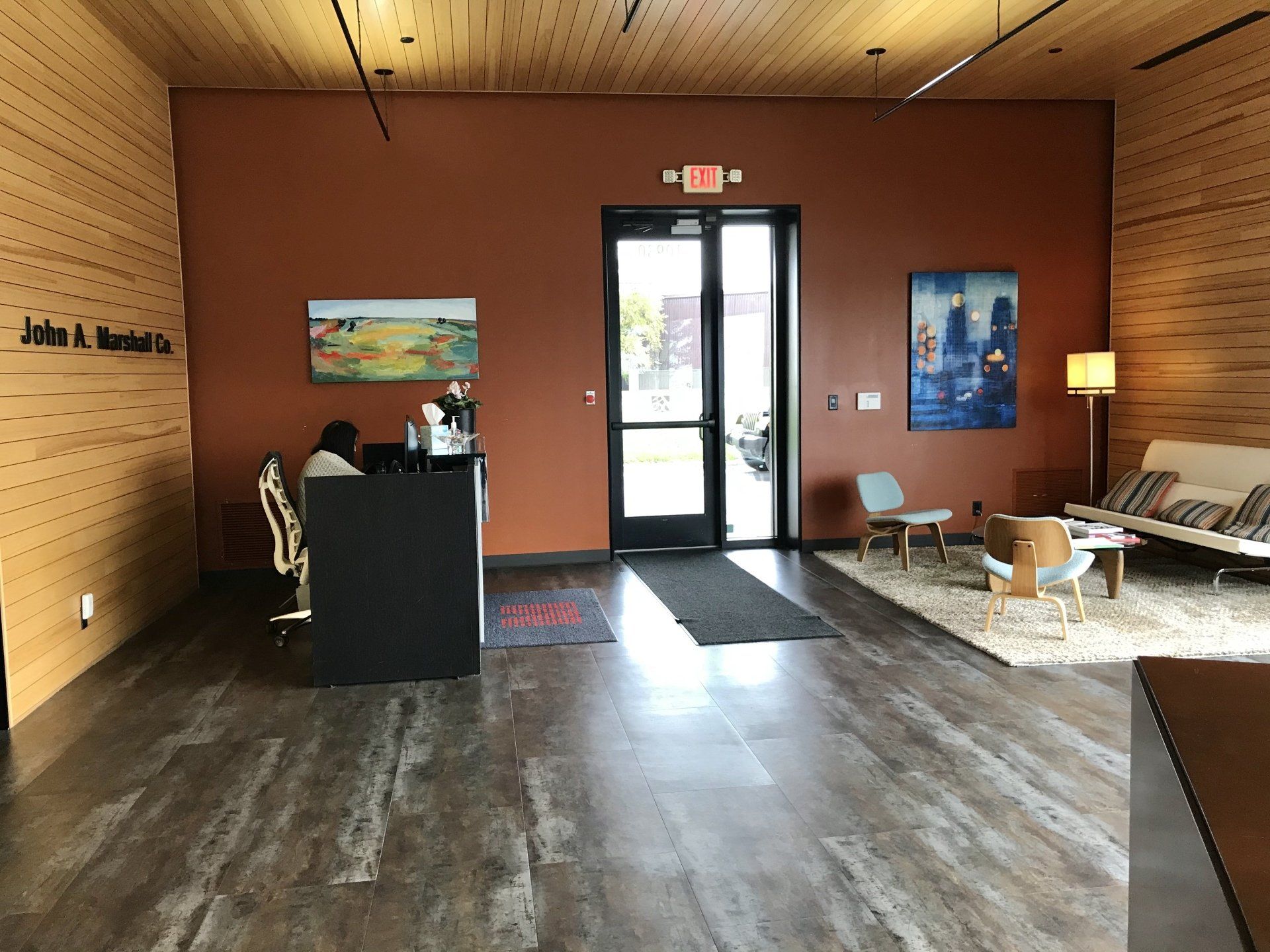 A reception area in a building with a couch and chairs