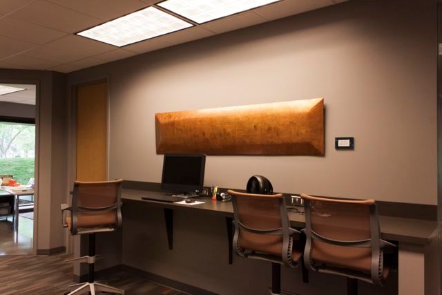 A room with a desk and chairs and a computer on it.