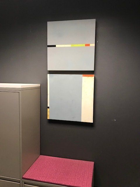 A painting is hanging on a wall next to a pink bench