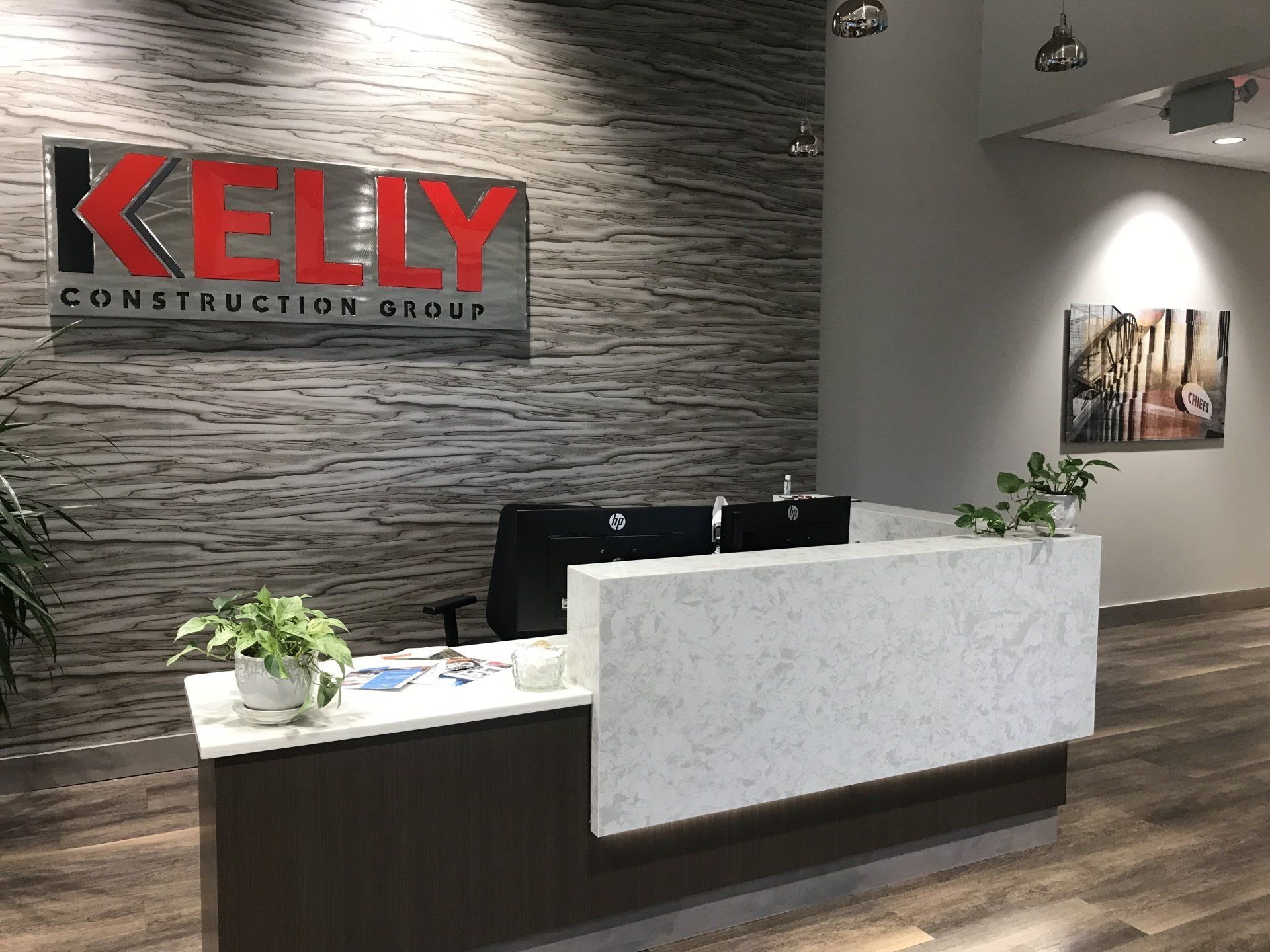 A kelly construction group sign hangs above a reception desk