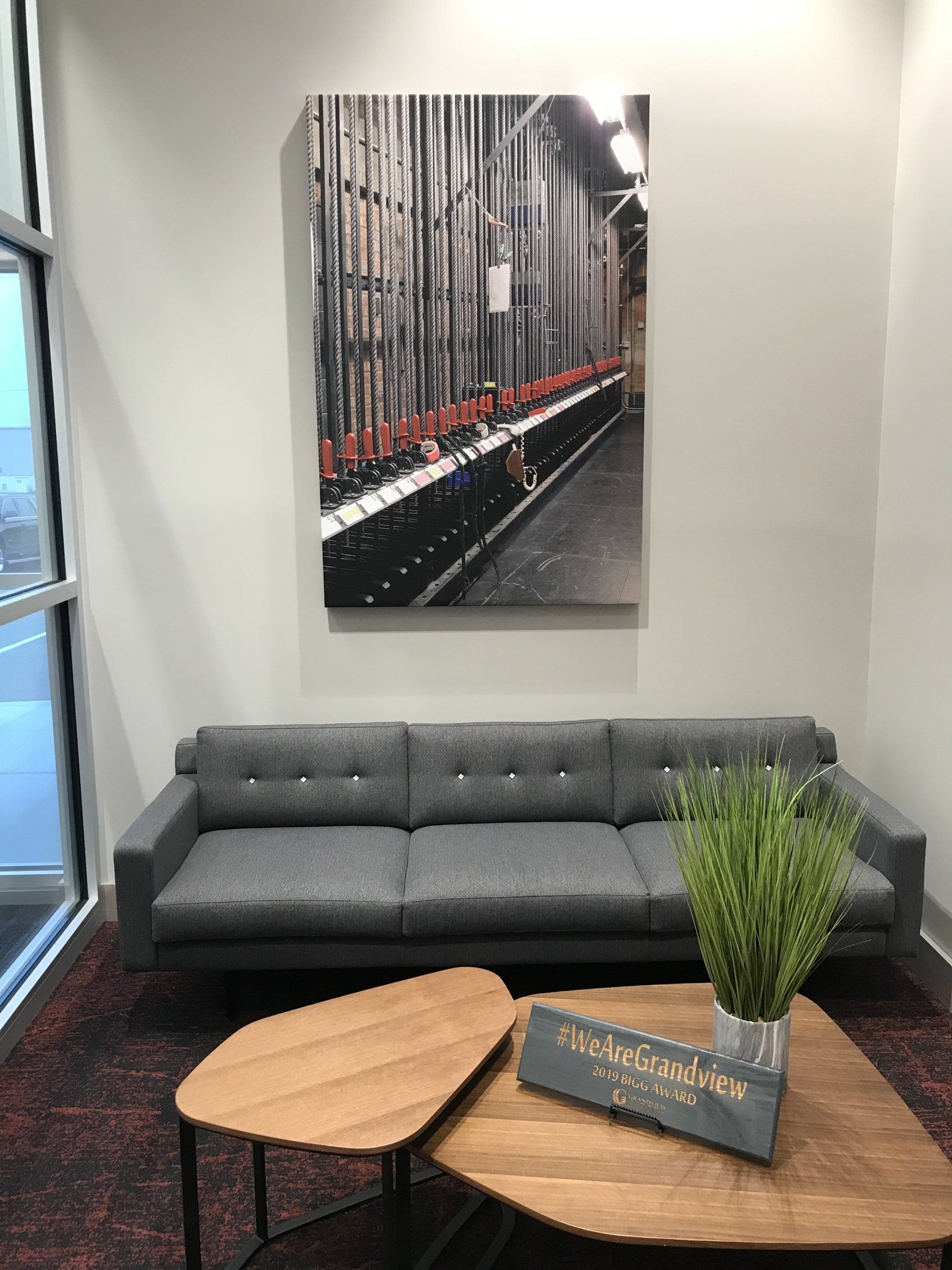 A living room with a couch , two coffee tables and a painting on the wall.