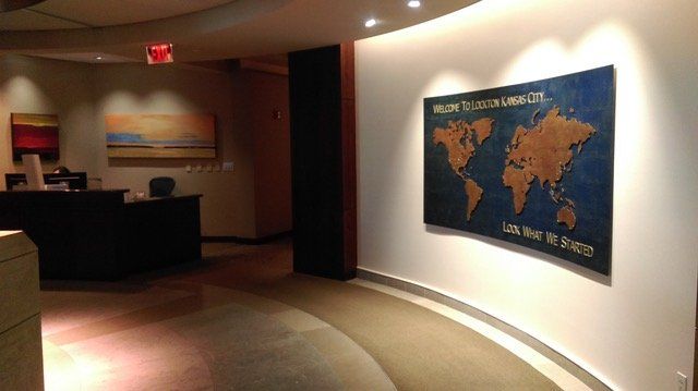 A large map of the world is hanging on a wall in a lobby.