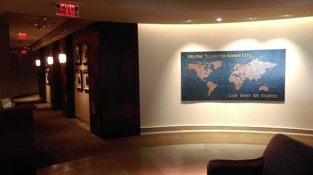 A large map of the world is hanging on a wall in a hallway.
