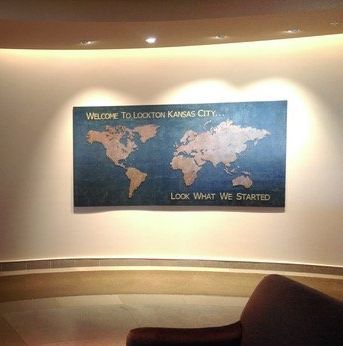 A large map of the world is hanging on a wall in a room.
