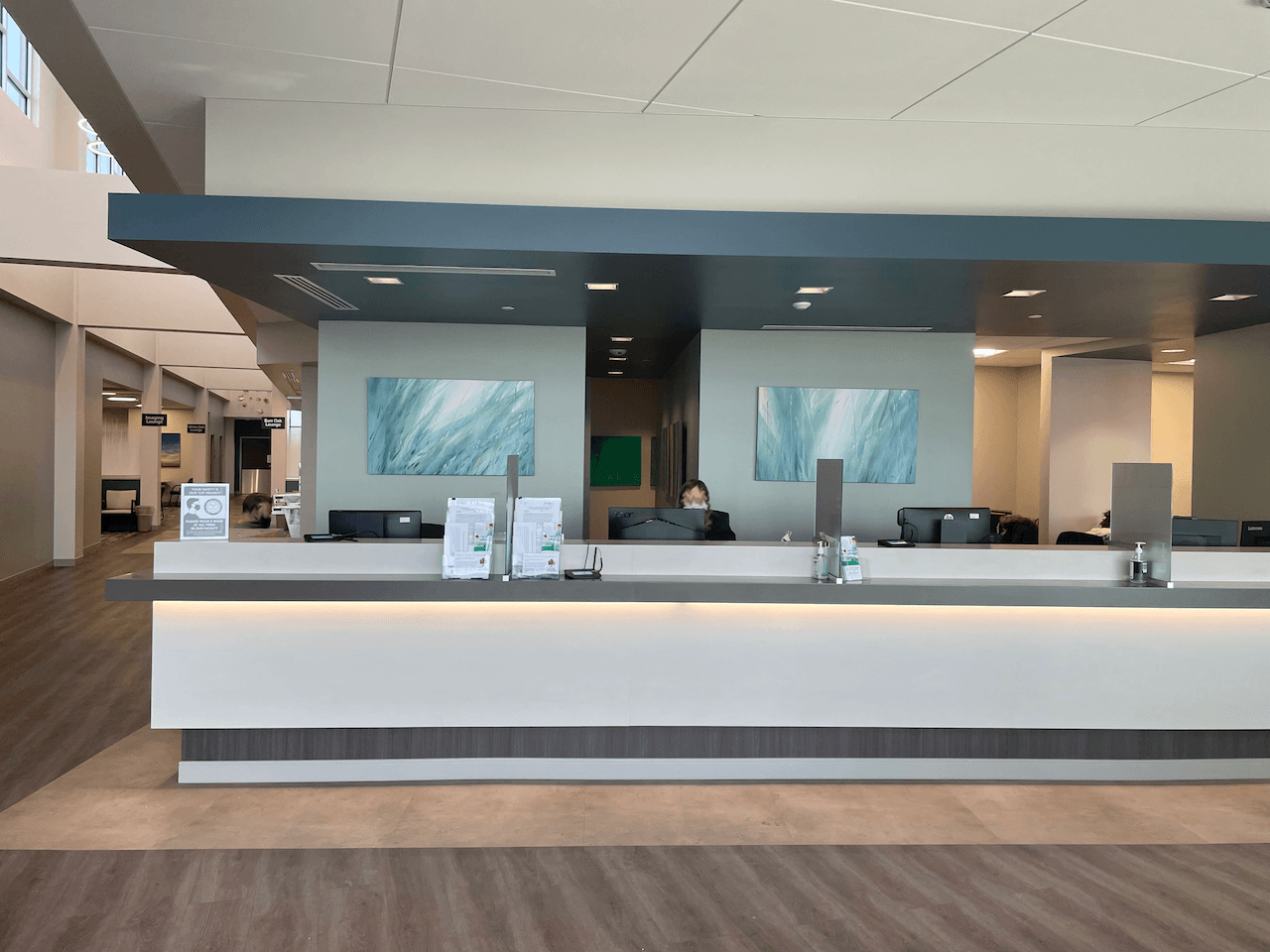 A woman is sitting at a reception desk in a hospital.