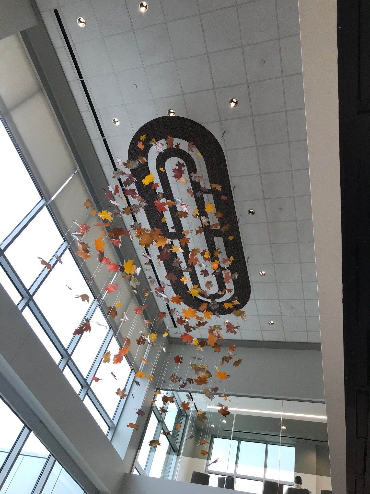 A large paper clip is hanging from the ceiling of a building