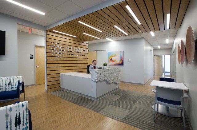 A man is sitting at a desk in a hospital lobby.
