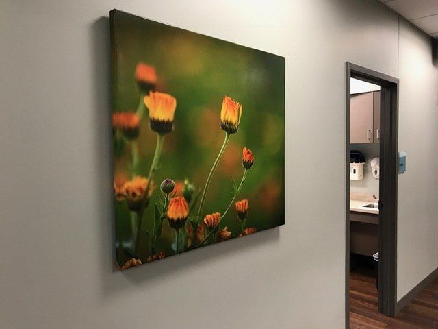 A painting of flowers is hanging on a wall in a hallway.
