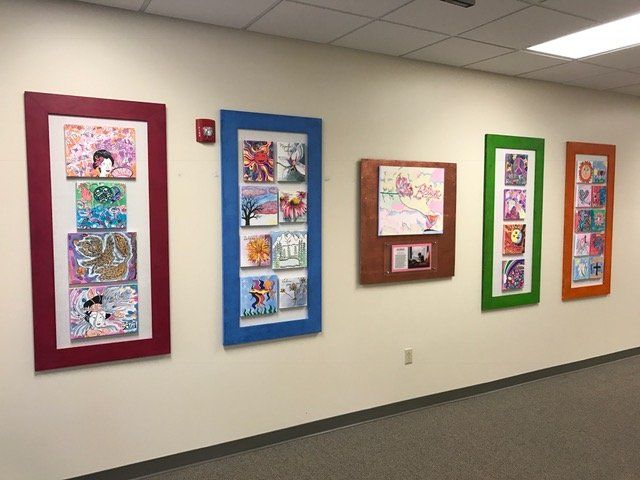 A hallway with a bunch of framed pictures on the wall