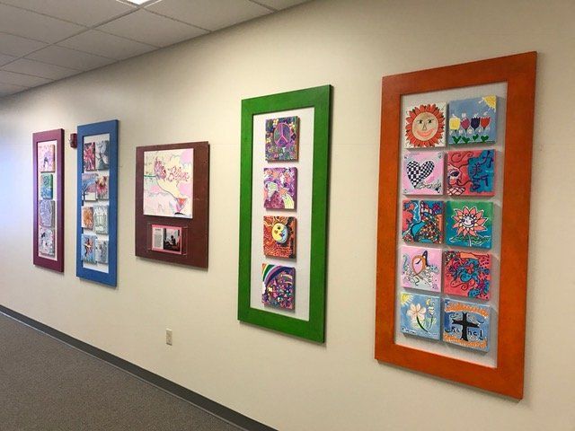 A hallway with a bunch of framed pictures on the wall