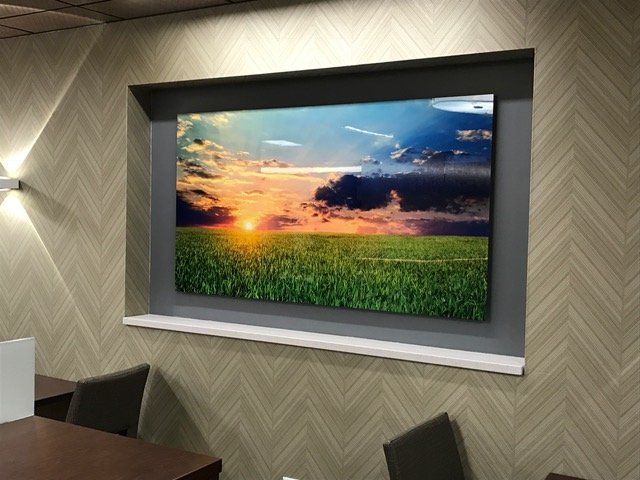 A picture of a field of grass is hanging on a wall