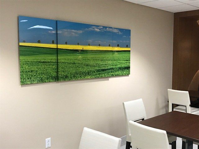 A room with a table and chairs and a painting on the wall