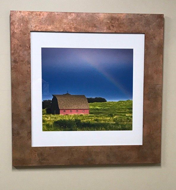 A picture of a barn with a rainbow in the sky