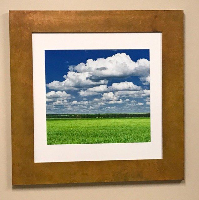 A picture of a field with clouds in the sky