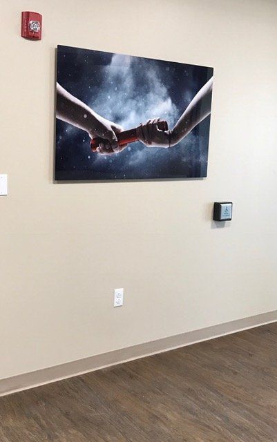 A picture of two people holding hands on a wall