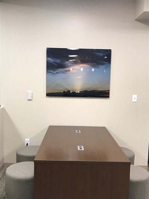 A room with a table and chairs and a painting on the wall.