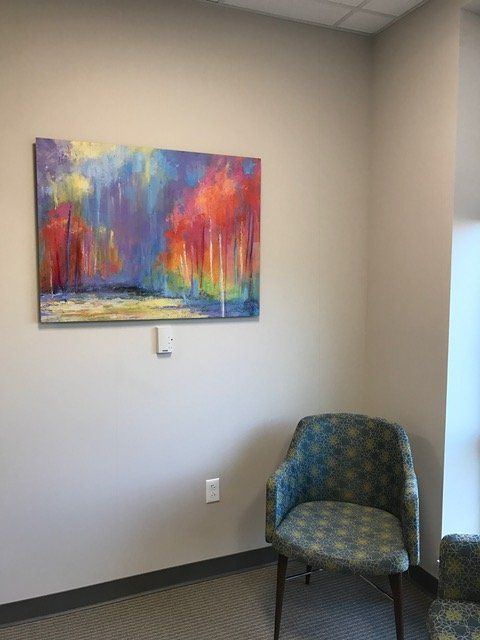 A room with a chair and a painting on the wall