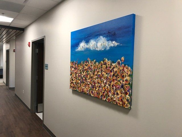 A large painting is hanging on a wall in a hallway