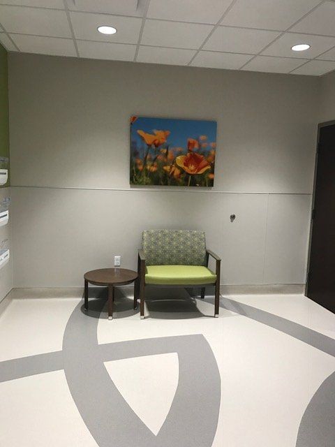 A chair and a table in a room with a picture on the wall