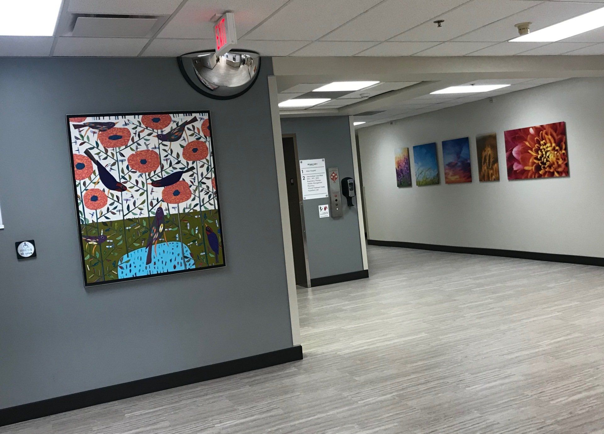 A room with a painting on the wall and a mirror on the wall.