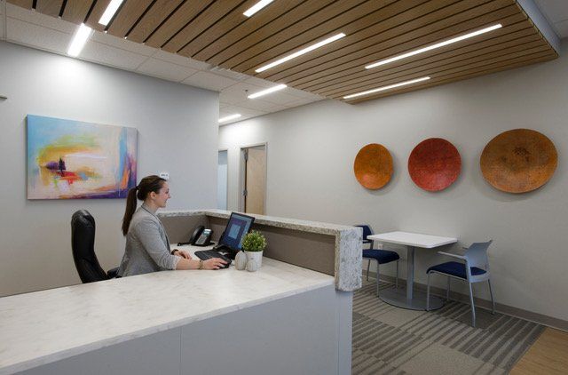 A woman is sitting at a desk in front of a computer.